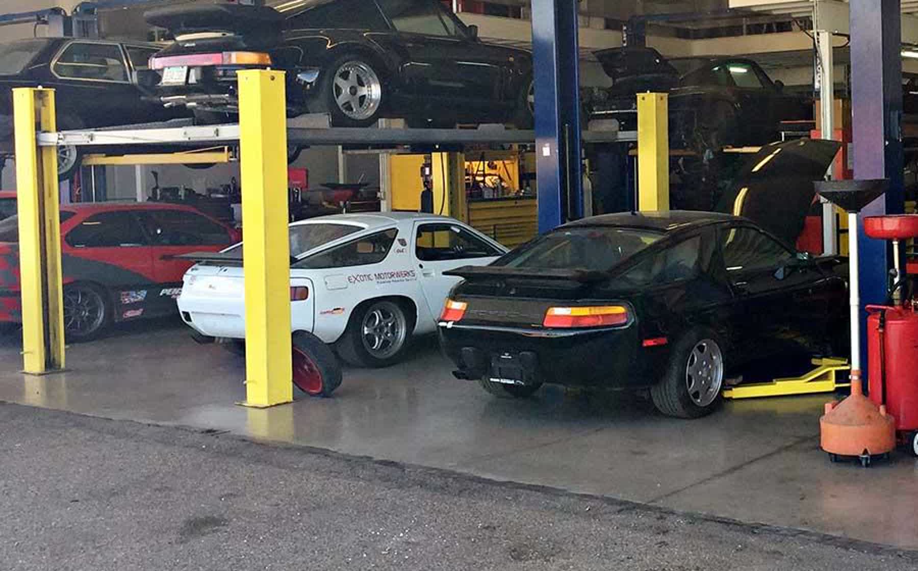 A white and a black Porsche 928 in the service bays at Exotic Motorwerks in Scottsdale