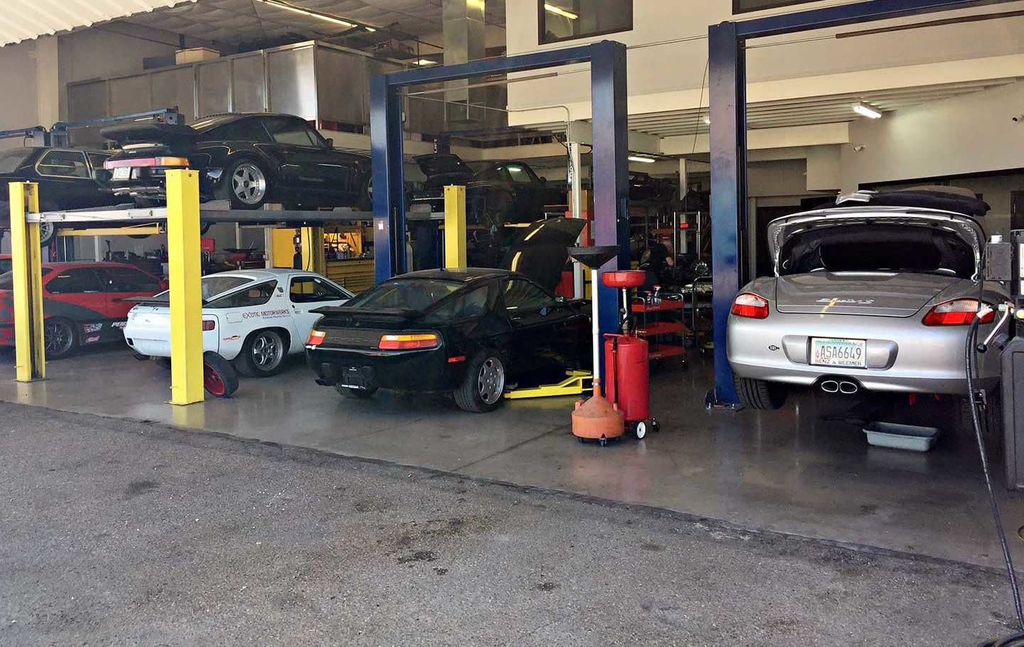 A white and a black Porsche 928 in the service bays at Exotic Motorwerks in Scottsdale