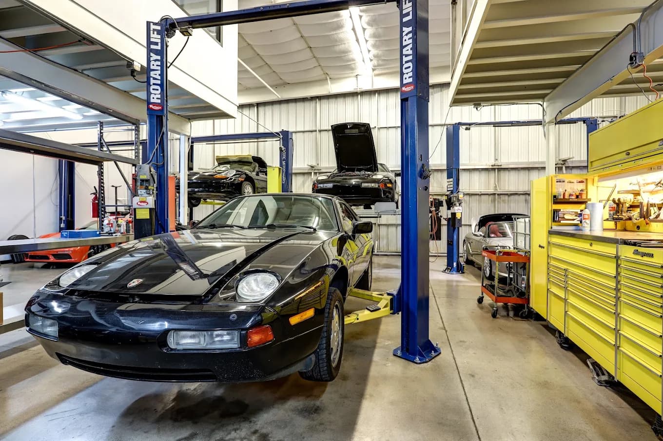 Porsche 928 and other Porsches on the lifts across the Exotic Motorwerks service bays in Scottsdale