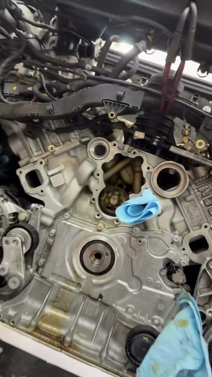 A Porsche engine with the front cover off, water pump and coolant passages open.